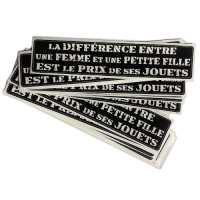 Sticker "La Différence entre une Femme et une Petite Fille est le Prix de ses Jouets". Text in French. Unit.