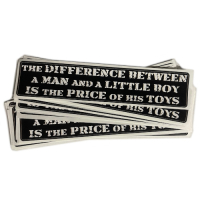Autocollant "The Difference Between a Man and a Little Boy is the Price of His Toys". Texte en Anglais. A l'unité.